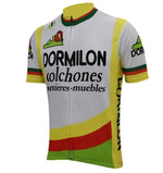 The Dormilon Colchones Retro Cycling Jersey features a vibrant design with a cartoon figure, made of lightweight polyester. Its mainly white with yellow, red, and green accents and showcases DORMILON colchones sommieres-muebles on the front.