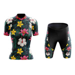 Discover the elegance of our Womens Floral Colourful Lily Cycling Jersey Set in pink, yellow, and white on a dark backdrop. This stylish set includes a short-sleeved jersey and matching shorts, perfect for adding flair to your ride.