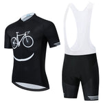 The Bike Smiley Face Cycling Jersey Set features a lightweight black polyester short-sleeve jersey with a white bicycle and smile graphic, paired with black and white bib shorts. Enjoy comfortable long rides thanks to the built-in gel seat pad.