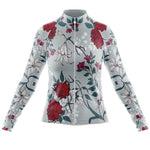 The Womens Long Sleeve Floral Big Red Jersey, available with a fleece option, features a light gray base adorned with red roses and white lilies in a floral pattern, complemented by subtle leafy motifs. It includes a full front zip for easy wear.