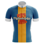 The Philadelphia USA Retro Cycling Jersey showcases blue and orange vertical stripes, a stylized Liberty Bell, and Philadelphia in cursive across the chest. It features a white collar and sleeve cuffs, capturing a classic retro design.