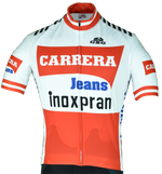 The Carrera Inoxpran 1984 Retro Cycling Jersey Set features a classic design with red/white sections and logos CARRERA in bold red, Jeans in blue, and inoxpran in black. It includes a front zipper and sleek black shoulder accents, reminiscent of the iconic 1984 cycling team look.