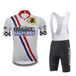 The Team Z Peugeot Halfords Retro Cycling Jersey Set features a white jersey with red, blue, and checkered stripes, adorned with Peugeot and Halfords logos. It includes black bib shorts with Peugeot text on the side and a gel seat pad for comfort during long rides.