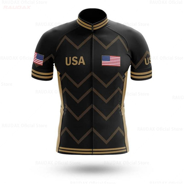 The USA Cycling Team Jersey is a lightweight polyester jersey with a black base, gold chevron patterns, and proudly displays USA and the American flag on the chest and sleeves, capturing the pro team spirit.