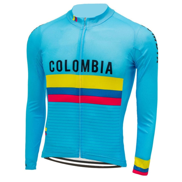 The Colombian Cycling Federation Jersey is a blue long-sleeve cycling jersey with COLOMBIA on the front and yellow, blue, and red stripes. It features a full front zipper, high collar, and winter fleece for cooler rides.