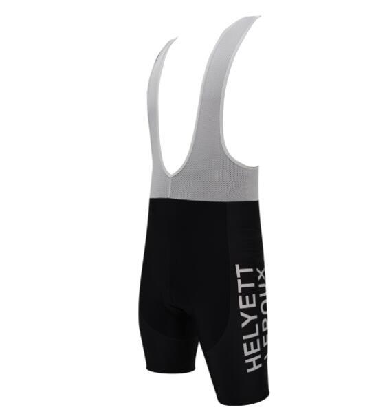 A side view of Helyett Leroux Bib Shorts showcases their black polyester fabric with white mesh shoulder straps, HELYETT printed vertically in white on the side, and a gel pad seat for added comfort.