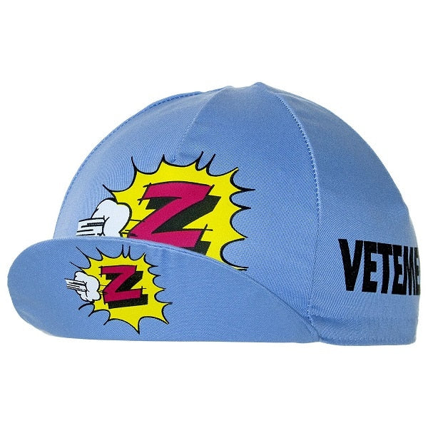 The Vetements Team Z Retro Cycling Cap is light blue with colorful comic-style Z graphics and fists on the side and front, featuring VETEMENTS printed in black, merging bold and playful retro styles.