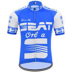 The SEAT Orbea Retro Cycling Jersey is blue and white with short sleeves, featuring the SEAT logo prominently in white. It has contrasting patterns on the sleeves and sides, celebrating renowned Orbea bicycles.