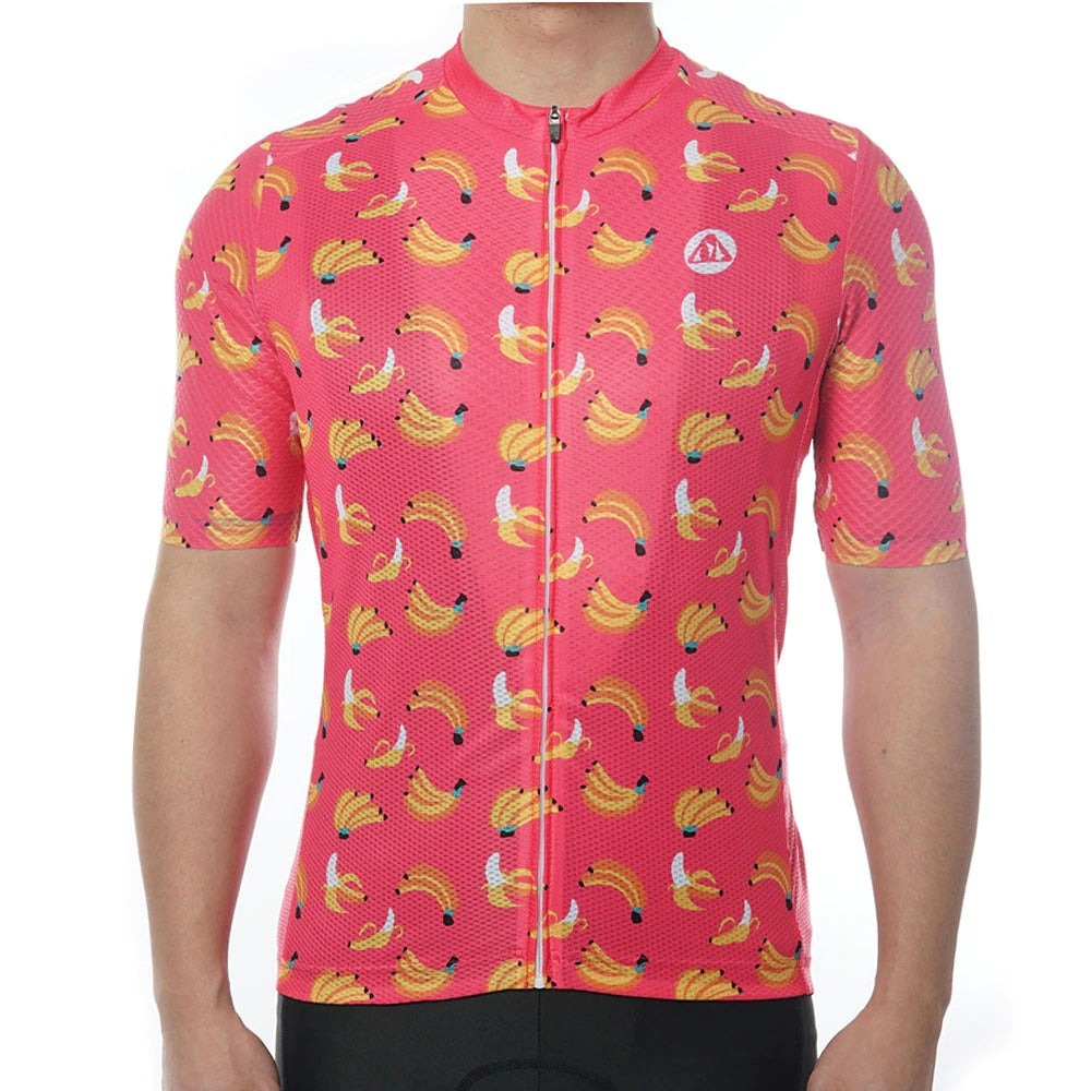 A person wears the Bananas Cycling Jersey, a banana-themed bright pink design crafted from lightweight polyester for enhanced performance. The short sleeves and front zipper complete this vibrant look against a plain white background.