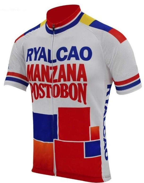 The Manzana Postobon Retro Cycling Jersey features a white base with bold geometric blocks in red, blue, and yellow. RYALCAO MANZANA POSTOBON is prominently displayed on the front in retro red and blue lettering, celebrating the iconic Colombian beverage manufacturer.