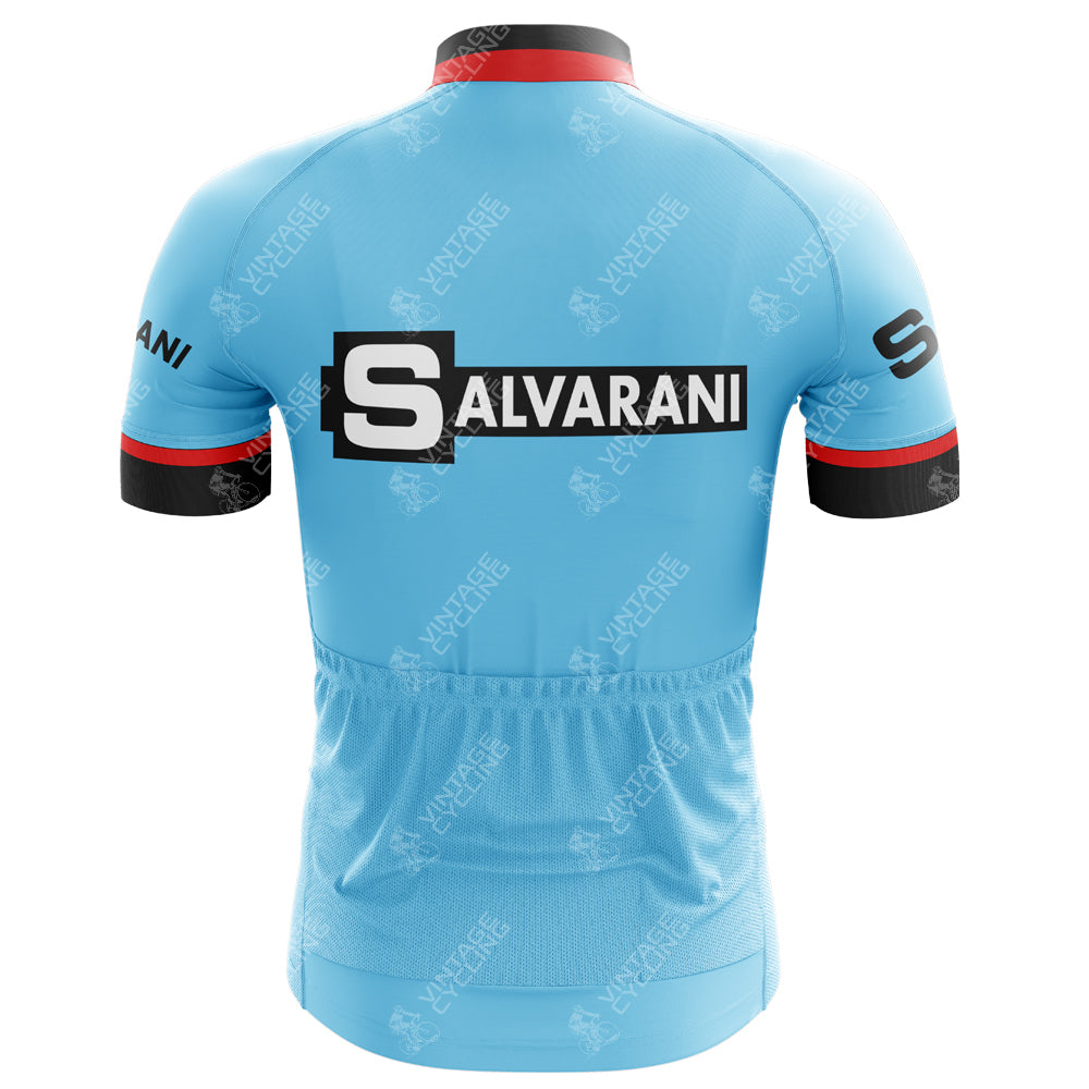 The Salvarani 1972 Retro Cycling Jerseys back view in light blue features SALVARANI printed boldly. Red and black accents enhance the sleeves and collar, while subtle bicycle graphics pay homage to legendary Grand Tours where Felice Gimondi triumphed.