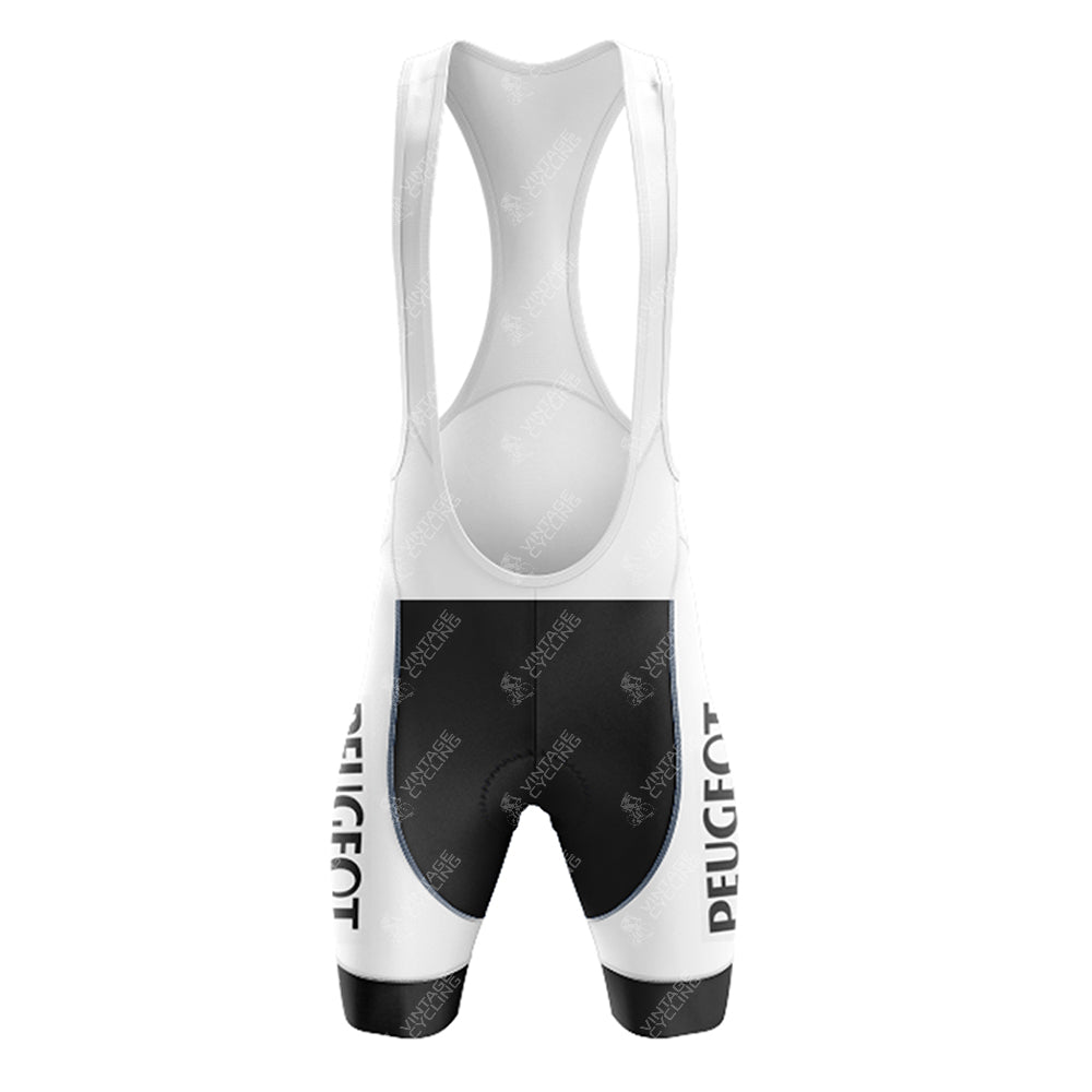 The front view of the Peugeot Black White Retro Short Sleeve Cycling Set shows vintage cycling bib shorts featuring a white and black color scheme with PEUGEOT vertically on the sides, shoulder straps, and a padded seat area.