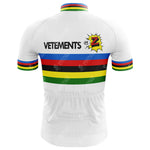 Back view of the Tomasso Team Z Vetements Jersey, a white cycling jersey recalling the Tour de France with blue, red, black, yellow, and green horizontal stripes. Vetements and a colorful burst logo with Z adorn the upper back.