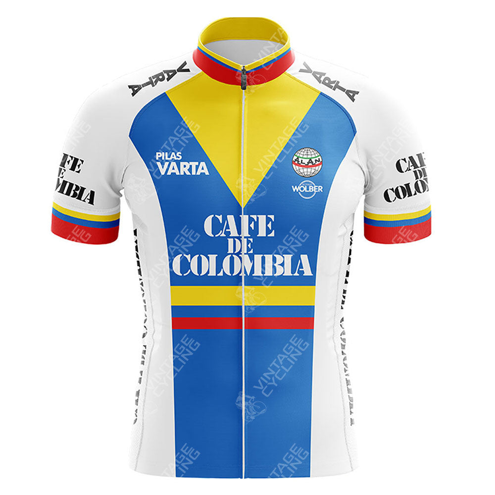 The CAFE D COLOMBIA Retro Cycling Jersey is made from lightweight polyester and features bold horizontal stripes in yellow, blue, and red. CAFE DE COLOMBIA prominently appears on the front with added black text and logos.