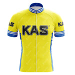 The KAS Yellow Retro Short Sleeve Cycling Set includes a cycling jersey with blue side panels and KAS in bold black letters on the front, plus matching shorts. The jersey features a zip-up front and blue trim on the cuffs and collar, creating a nostalgic look.