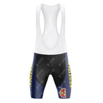 The Festina Watches Retro Cycling Jersey Set includes bib shorts with a white upper, navy blue and black lower sections, and a gel seat pad for comfort. Yellow text and a circular red and blue emblem decorate one leg, while the fabric features a subtle logo pattern.