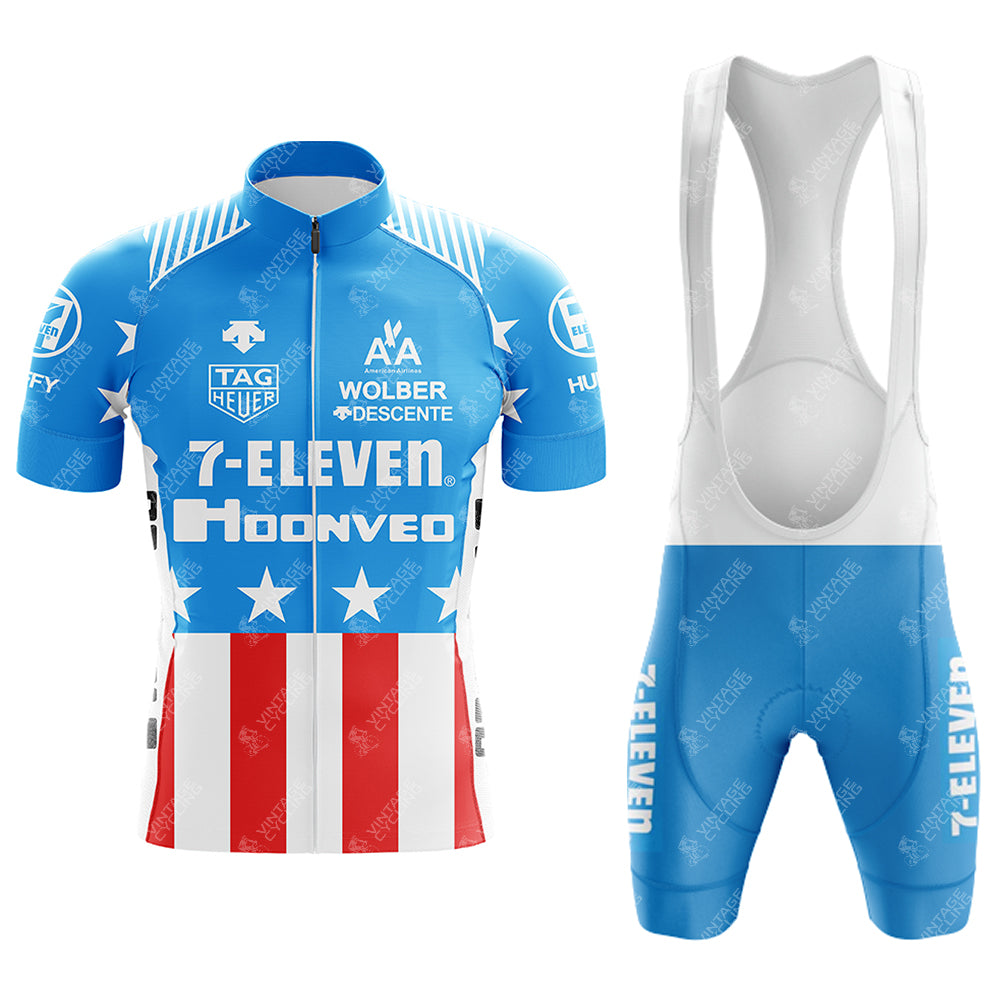 Blue short sleeve 1990s 7-ELEVEN Retro Cycling Set features bib shorts with white stars, red stripes, multiple logos, and 7-Eleven text. It includes white straps that complement the matching blue and white theme.