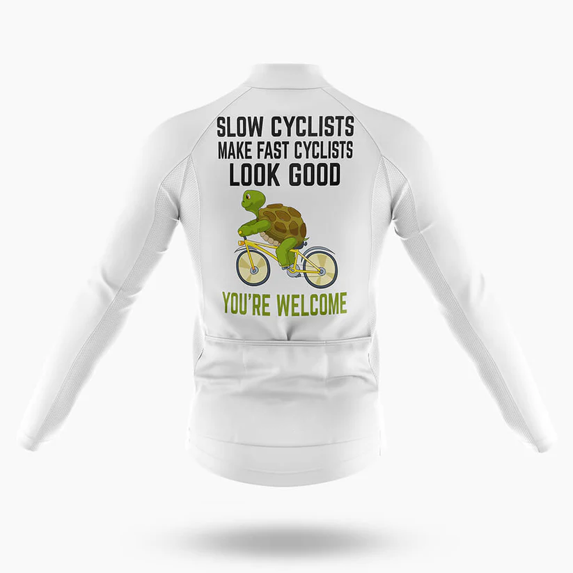 The Specialized V2 Men Long Sleeve Cycling Jersey in white features a cartoon turtle on a bike with the fun text “Slow cyclists make fast cyclists look good” above and “You’re welcome” below—perfect for cool-weather rides.