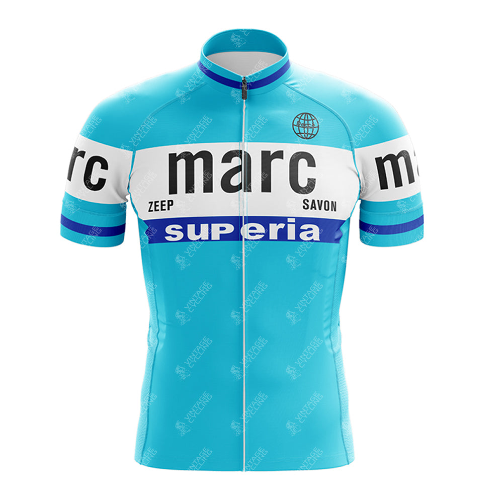 The Marc Superia Blue Retro Short Sleeve Cycling Set features light blue fabric with white and blue stripes, black "marc" text, ZEEP, SAVON, superia in white/black, a front zipper, and a small globe icon.