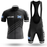 The Drinking Men Short Sleeve Cycling Set features a black men's jersey with SCOTLAND text, Scottish flag, front zipper, and matching bib shorts with shoulder straps and white accents—a tribute unlike any Chicago flag jersey.
