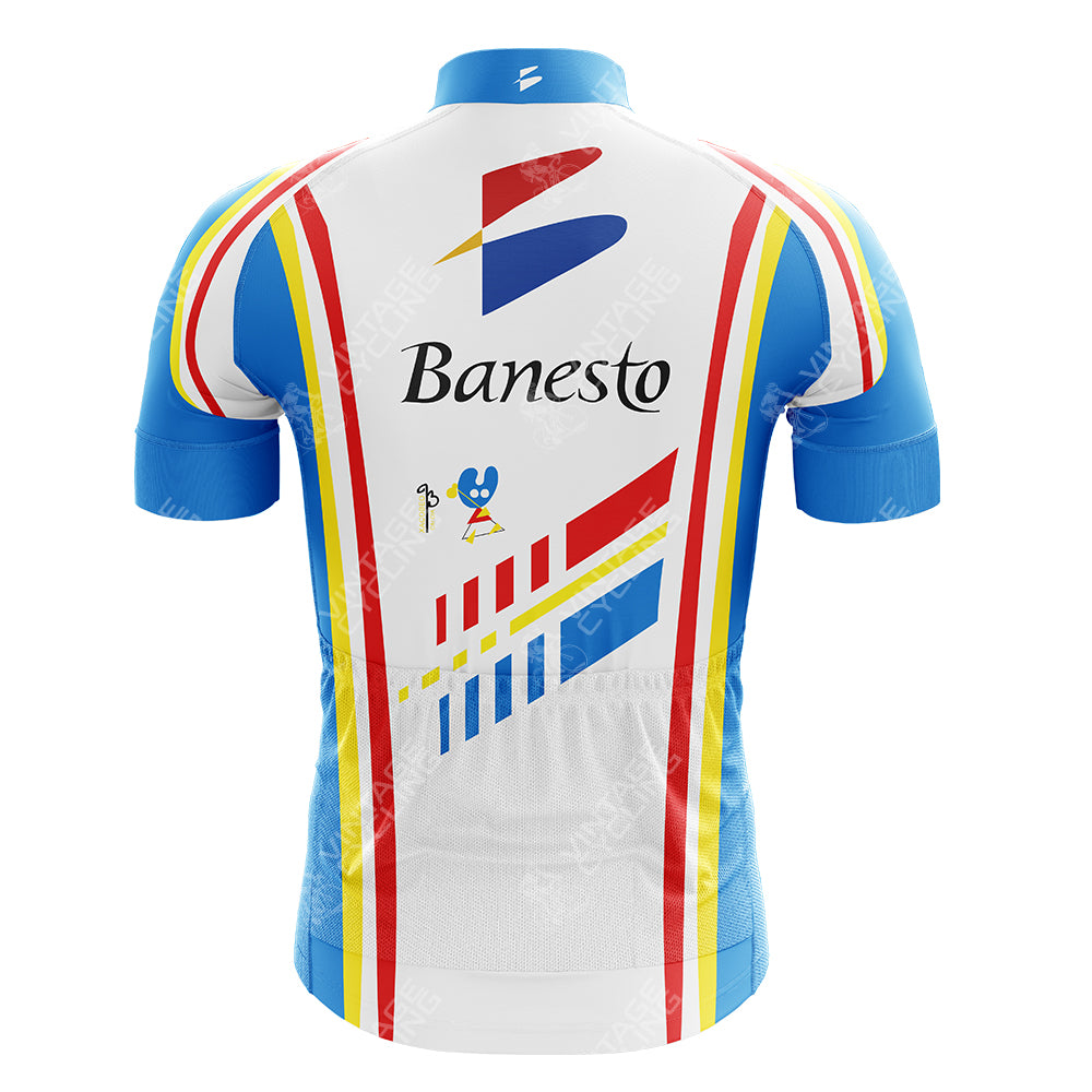 The FESTINA Retro Cycling Jersey combines retro cycling elegance and playful design in blue and white, with red and yellow stripes. Featuring Banesto on the front and a cartoon mouse holding a flag, it offers style and nostalgia for cycling enthusiasts.