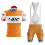 The BIC Orange Retro Short Sleeve Cycling Set has a vintage flair, featuring an orange and white jersey with a front zip, blue and red accents on the collar and sleeves, and BIC across the chest. The matching bib shorts have logo straps and side logos for a cohesive retro look.