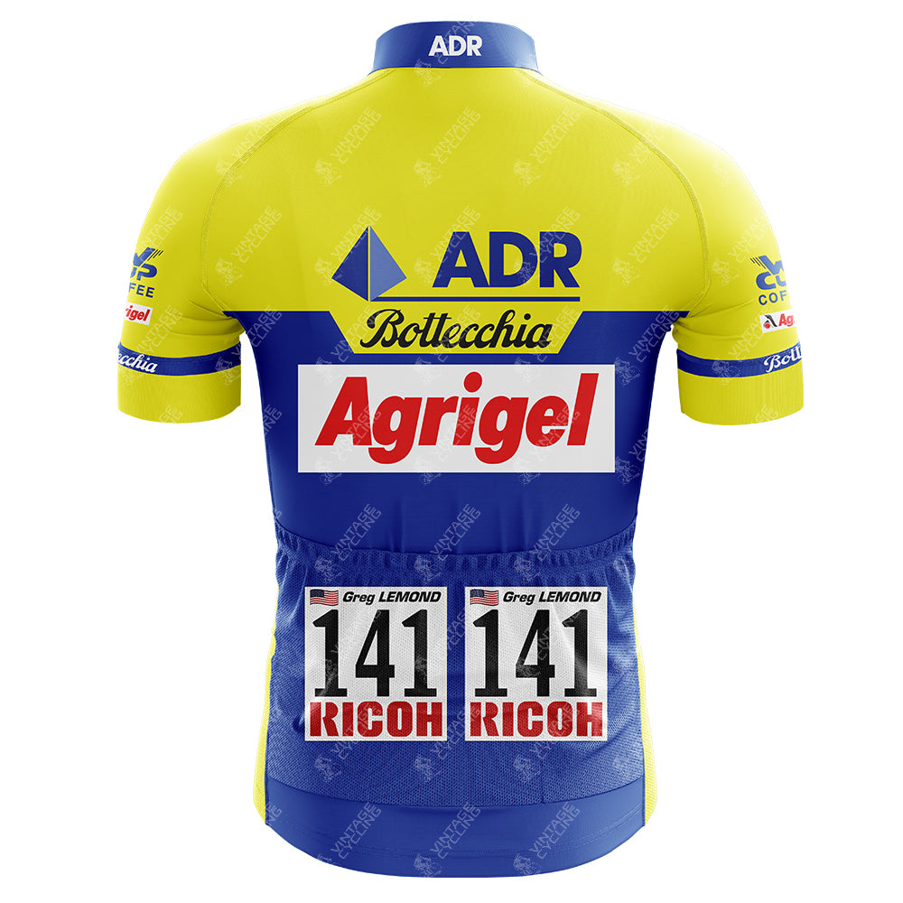 The back view of the 1989 ADR Retro Short Sleeve Cycling Set cycling jersey showcases sponsors logos and race number 141, with Greg Lemond and RICOH printed twice on the lower back, embodying vintage cycling style.
