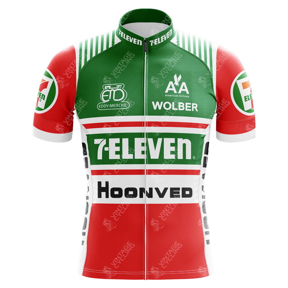 The 7-Eleven Retro Cycling Jersey Set features a vintage design with green, white, and red stripes, plus Eddy Merckx and Wolber logos. Made from breathable polyester, it includes short sleeves and a front zipper for optimal riding comfort.