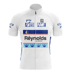 The SCIC Retro Short Sleeve Cycling Set is a white jersey with blue accents, featuring Paris Nice, Reynolds, and Perrier logos. It includes crown motifs on the bottom and chest, a front zipper, and blue side panels.