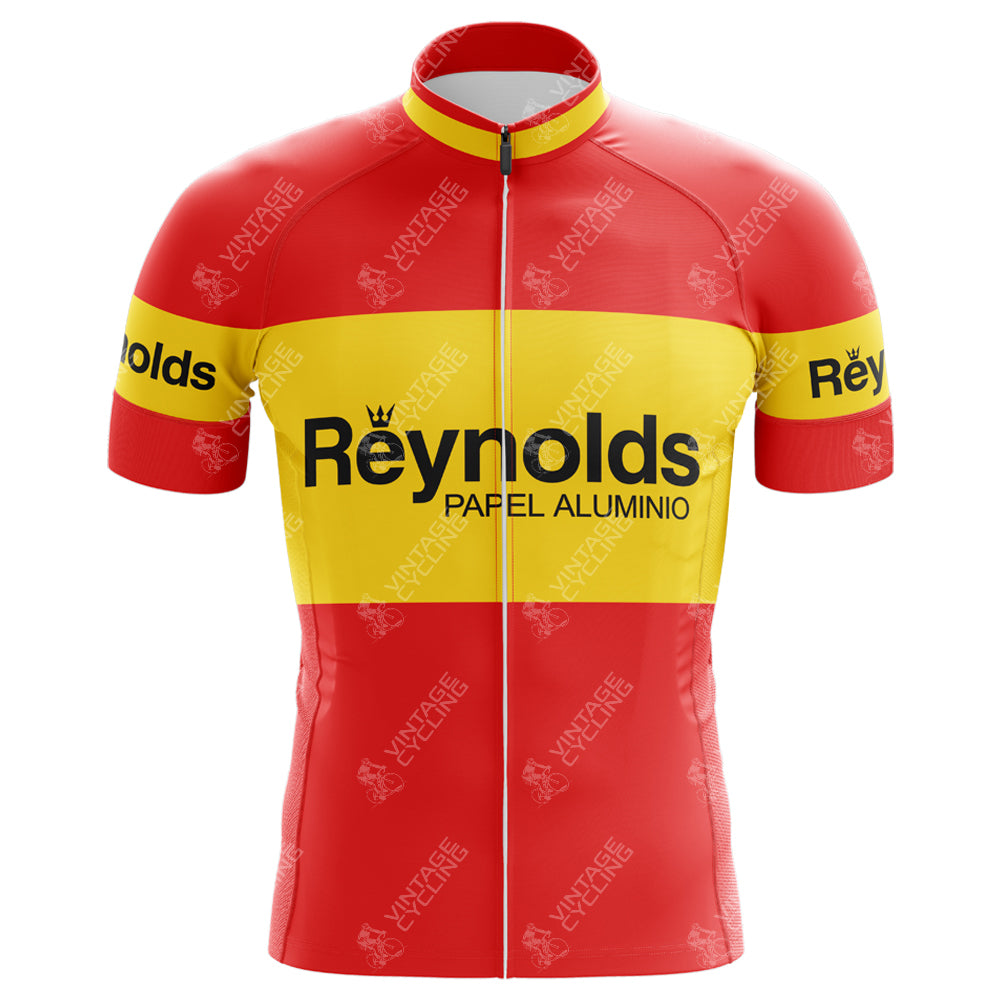 The Reynolds-Papel Alumino Retro Cycling Jersey is a lightweight polyester jersey in vibrant red with yellow horizontal stripes on the chest and sleeves. It features Reynolds-Papel Alumino in bold black letters across the front for a classic, vintage look.