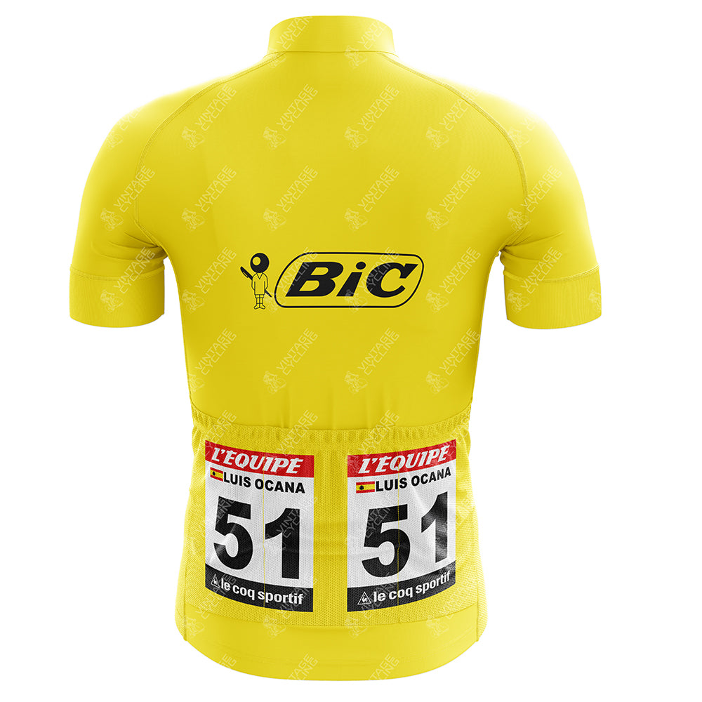 The BIC 1973 Luis Ocana Retro Cycling Jersey is yellow with a large Bic logo on the back above racing numbers 51, and labels for LEquipe, LUIS OCANA, and Le Coq Sportif, capturing the essence of the 1973 Tour de France.