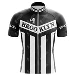 The Brooklyn Chewing Gum Retro Cycling Jersey features a black and white design with bold Brooklyn text, vertical stripes inspired by classic gum packaging, and a stylized bridge graphic reminiscent of Roger de Vlaemincks iconic era.