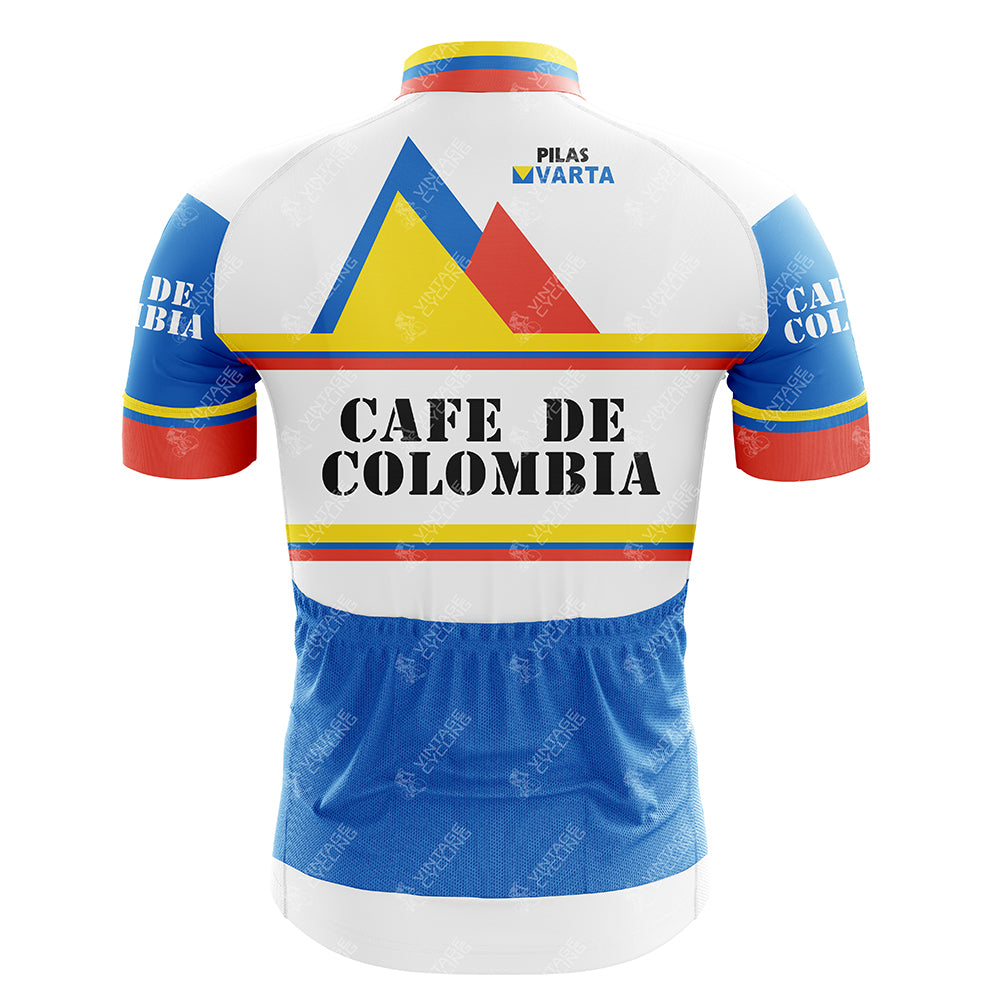 The CAFE DE COLOMBIA V2 Retro Cycling Jersey displays vibrant mountain graphics with blue, orange, and yellow accents. Cafe de Colombia is boldly printed on the back, with Pilas Varta above. Crafted from lightweight polyester, the jerseys bottom half prominently features blue.