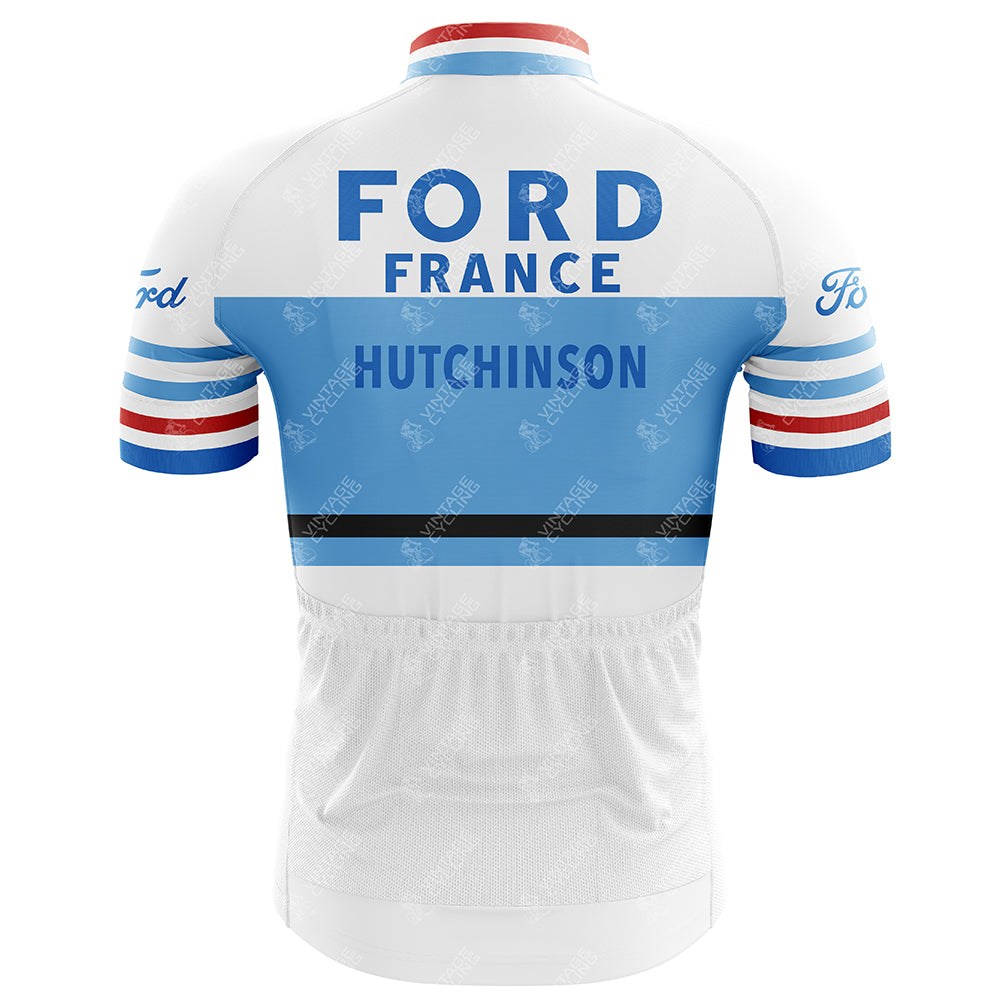 The Ford France Hutchinson Retro Cycling Jersey features a back view in white and light blue with bold FORD FRANCE and HUTCHINSON. It has lightweight polyester, blue and red striped sleeves, and the Ford logo on the shoulders.
