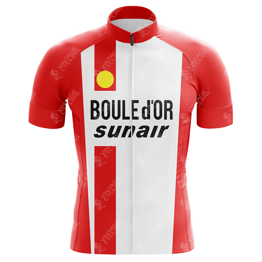 The Freddy Maertens 1981 Boule d’Or Sunair Retro Cycling Jersey is a red and white piece with a front zipper, lightweight polyester fabric, yellow shoulder logo, and BOULE DOR and sunair in bold black text across the chest, evoking Maertens iconic style.