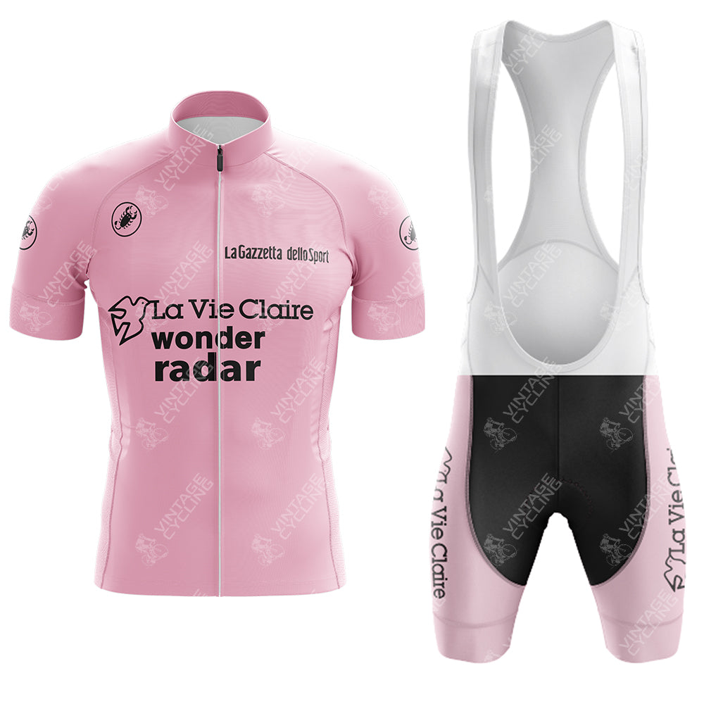 The Wonder Radar La Vie Claire Retro Short Sleeve Cycling Set includes a pink jersey with black logos, a full-length zipper, and white side panels. The matching bib shorts feature white straps, a black seat panel, and coordinating sponsor logos on the sides.