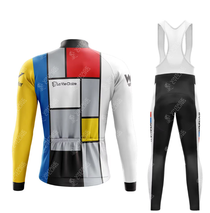 The La Vie Claire Retro Cycling Jersey Long Set, available with a fleece option, features a geometric design with red, blue, yellow, black, and white blocks on the jersey and primarily black bib pants with white and colored accents.