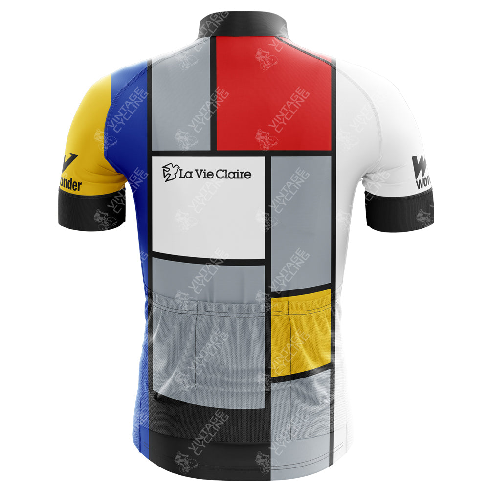 The La Vie Claire Retro Cycling Jersey Sets back view highlights a Piet Mondrian-inspired design with blocks of white, red, blue, yellow, and black. It features the La Vie Claire logo and black sleeves with Wonder text.