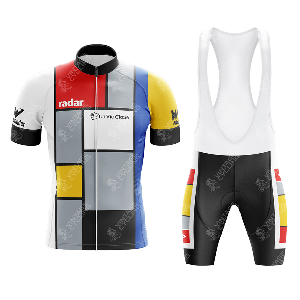 The La Vie Claire Retro Cycling Jersey Set includes a jersey with a full zip front and bib shorts with white straps. It features a Piet Mondrian-inspired design with bold geometric color blocks in red, yellow, blue, black, and gray.