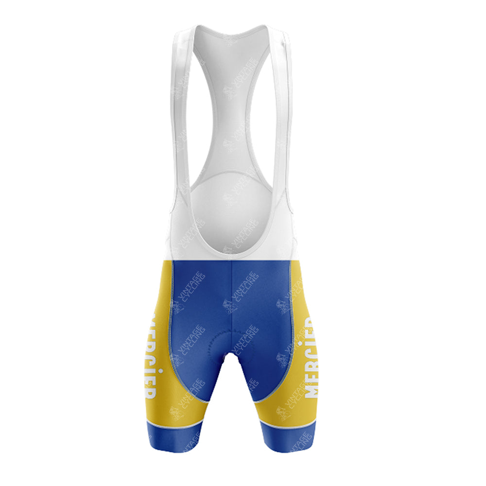 The front view of the Mercier Retro Short Sleeve Cycling Set bib showcases a blue, yellow, and white design with MERCIER printed in white on the colorful sections. The upper section is crisp white with supportive shoulder straps, giving it a classic cycling jersey style.