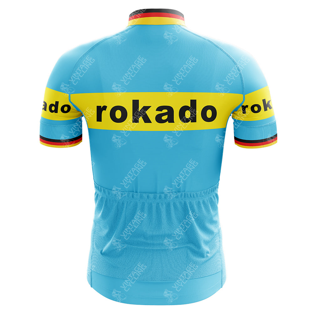 Back view of the Rokado Retro Cycling Jersey in light blue with a yellow stripe bearing rokado in black. Made from lightweight polyester, this performance jersey features cuffs with red, black, and yellow stripes.