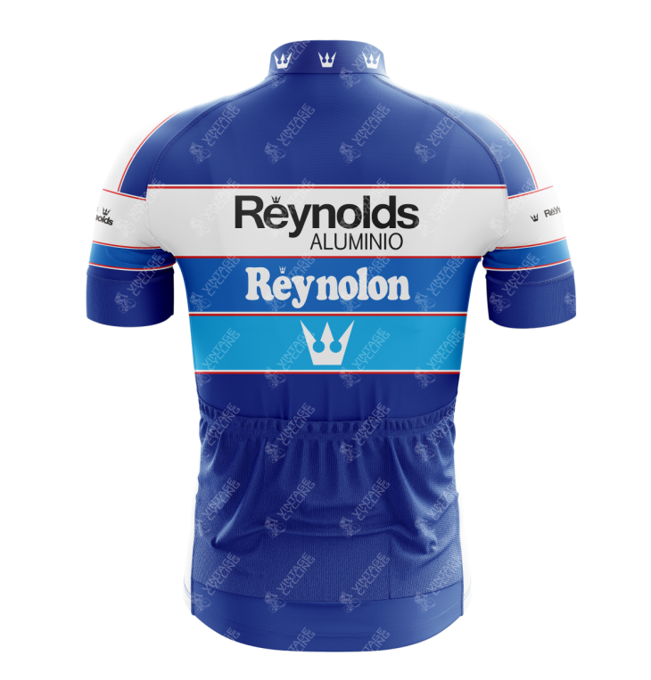The Reynolds Aluminio Retro Cycling Jersey is a blue and white design featuring Reynolds Aluminio, Reynolon, and a crown logo. The vintage Tour de France style showcases horizontal stripes reminiscent of Pedro Delgados era with multiple small crown logos.