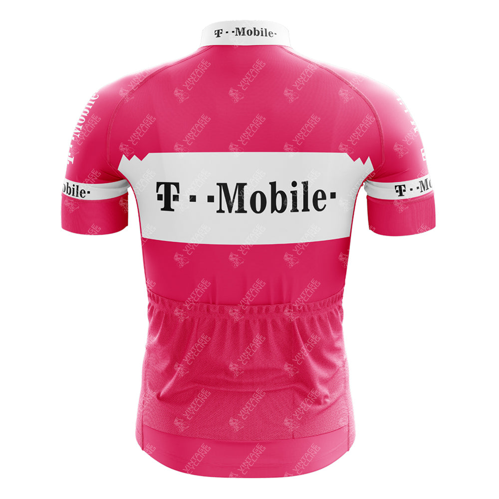 The T-Mobile Retro Short Sleeve Cycling Set is a pink jersey with bold white T-Mobile logos on the back and arms, a horizontal white stripe across the upper back, and smaller logos throughout for a vintage look.