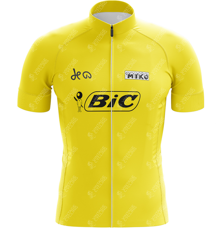 The Team Bic Retro Yellow Cycling Jersey, inspired by the 1973 Tour de France, features a maillot jaune design with short sleeves, black logos including BIC and Nike, a full front zipper, and a stand-up collar.