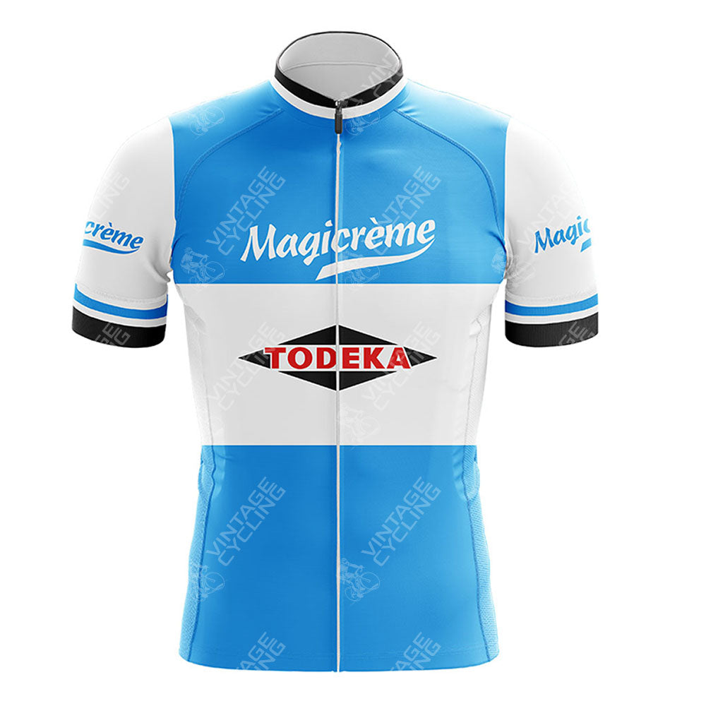 The Margnat Paloma Retro Short Sleeve Cycling Set features a blue and white jersey with Magicrème on the chest and sleeves, a Todeka logo in a black diamond on the front, and a front zipper for comfort and style.