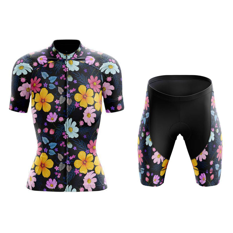 The Womens Floral Big Yellow Cycling Jersey Set features a lightweight polyester, black short-sleeve jersey and shorts adorned with vibrant yellow, pink, and blue flowers. It includes a gel seat pad for extra comfort on every ride.
