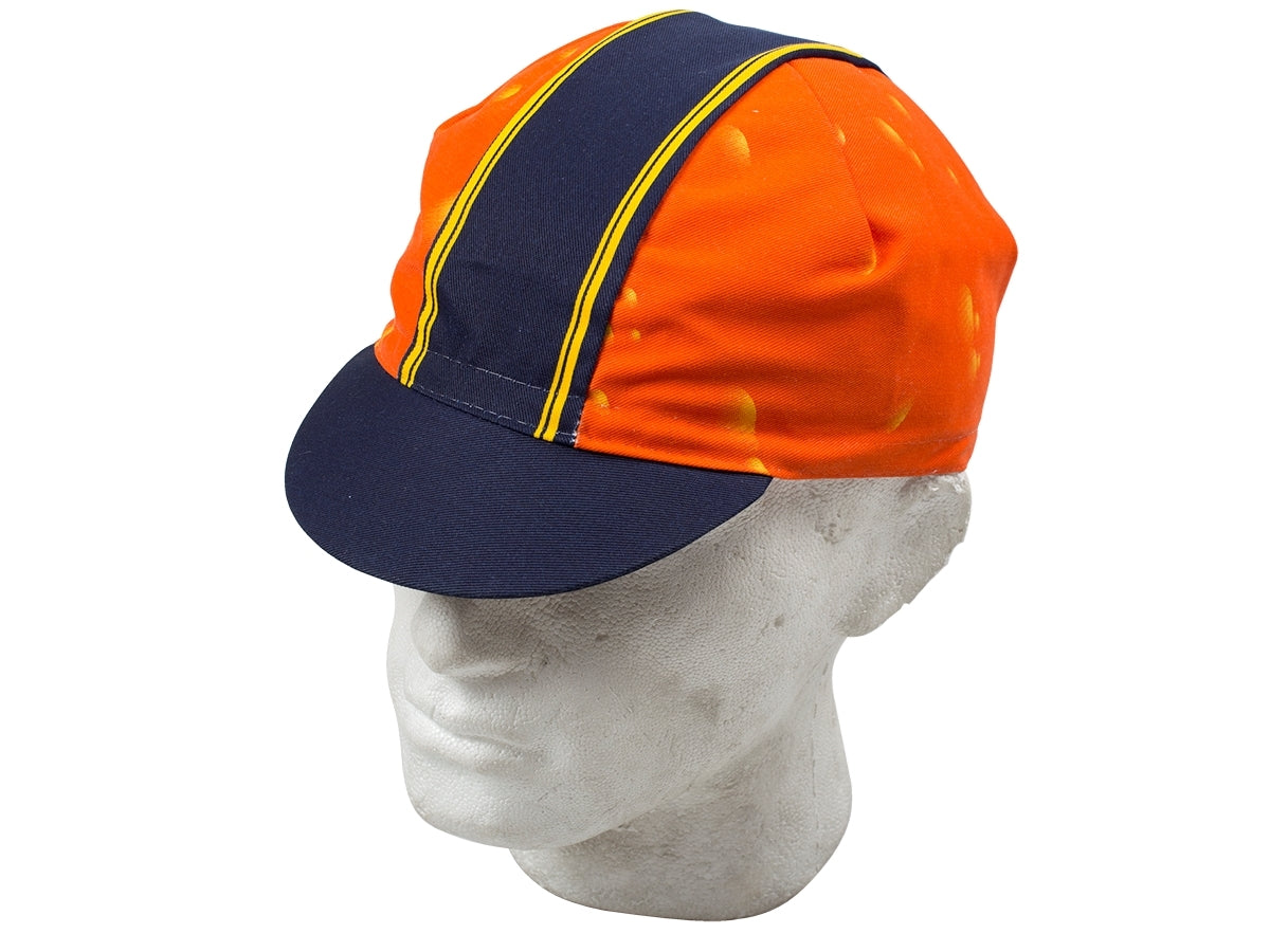 The Aperol Retro Cycling Cap, shown on a mannequin head, features a classic retro design with an orange base, navy brim, and a central blue stripe edged in yellow. The vibrant contrast between orange and blue gives it a unique vintage appeal.