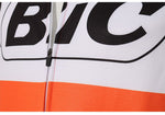 Close-up of a BIC Orange Long Sleeve Retro Cycling Jersey, featuring bold black BIC lettering on a white background with an orange band below. A visible vertical zipper runs through the center.