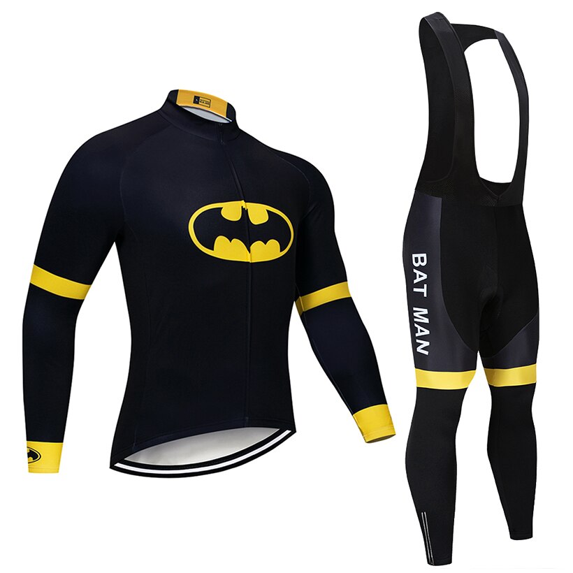 The Batman Cycling Jersey Long Set features a stylish black and yellow design with long sleeves and bib pants. Ideal for cooler rides, it has a fleece lining, a bat-like logo on the top, and BAT MAN prominently featured on the side of the pants.