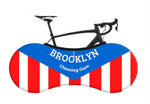 A bicycle illustration is cleverly woven into the retro red, white, and blue design of the Brooklyn Chewing Gum Bike Sock, styled to resemble a peanut shape with vertical stripes that evoke classic nostalgia.